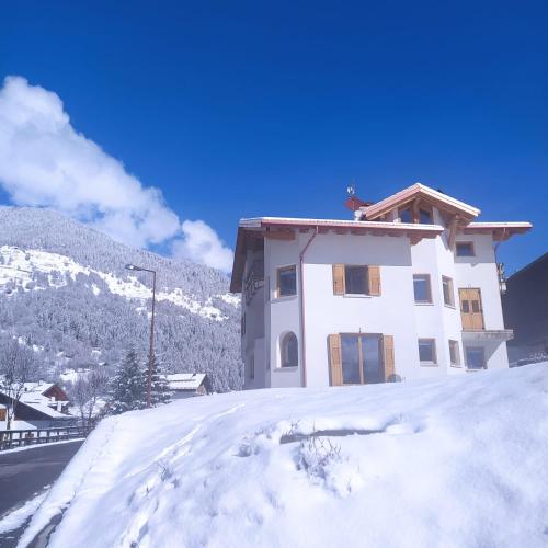 a house on top of a snow covered hill at Appartamento Mary - Casa Green - Dog friendly, box auto in Cogolo