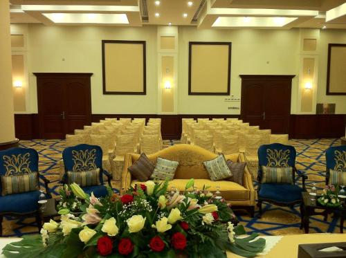 a conference room with a table and chairs and flowers at Holiday Jazan Hotel in Jazan