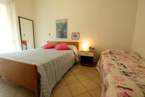 een slaapkamer met 2 bedden en een spiegel bij Armonia Pineto Vacanza in Pineto