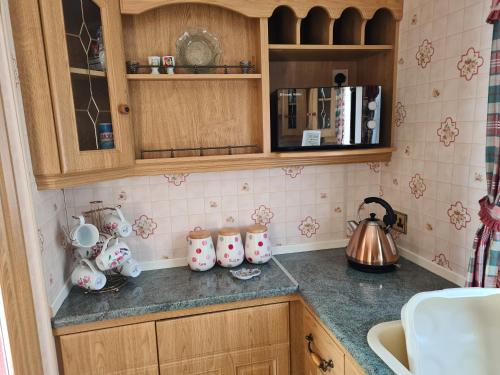 a kitchen counter with cups and a tea kettle at 6 berth Trusthorpe Springs (Mayfair) in Sutton on Sea
