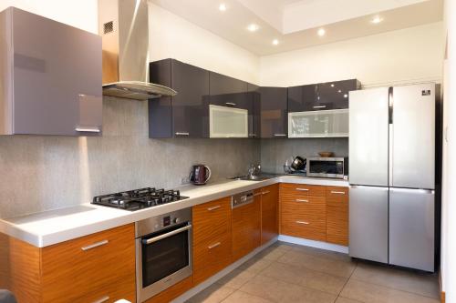 a kitchen with wooden cabinets and stainless steel appliances at ClickTheFlat Legionowo Apart Rooms in Legionowo