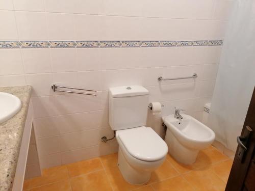 a bathroom with a toilet and a sink at Villa 88 in Almancil