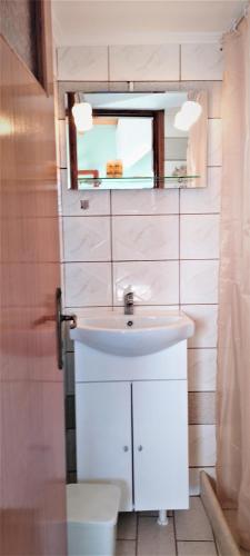 a bathroom with a white sink and a mirror at AGNANTIO in Monemvasia