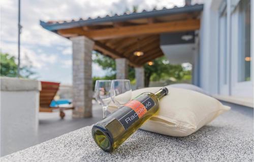 a bottle of wine sitting on a table with a glass at Four-Bedroom Holiday Home In Manjadvorci in Manjadvorci
