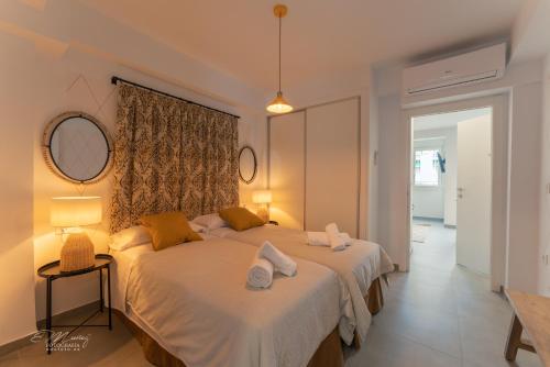 a bedroom with two beds and a mirror at Apartamentos Lorian in Mérida