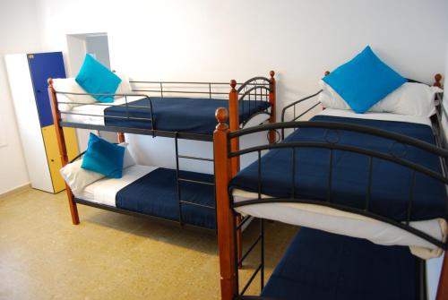 two bunk beds in a room with blue pillows at Estrella de Mar Youth Hostel in Calella