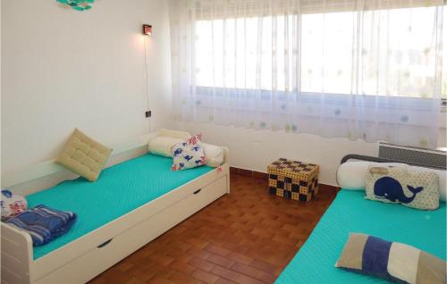 ein Kinderschlafzimmer mit 2 Betten und einem Fenster in der Unterkunft Gorgeous Apartment In Carnon Plage With House Sea View in Carnon-Plage