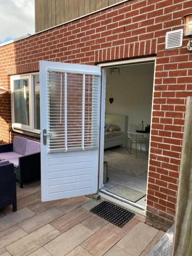 an open door to a brick building with a patio at Studioverhuur Vlissingen in Vlissingen