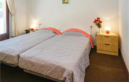 a bedroom with a bed and a table with a vase of flowers at Awesome Home In Pierrerue in Pierrerue