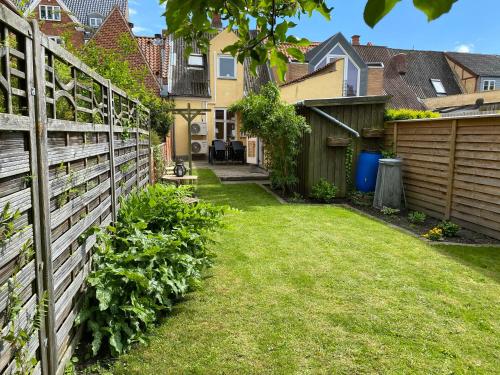 a backyard with a fence and a yard with grass at Nakskov Overnatning in Nakskov