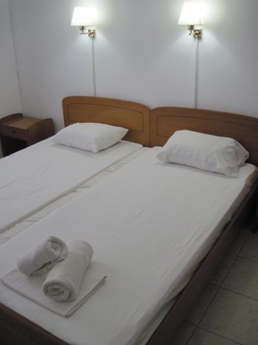 a bed with two towels on top of it at Tatsis Apartments in Masouri