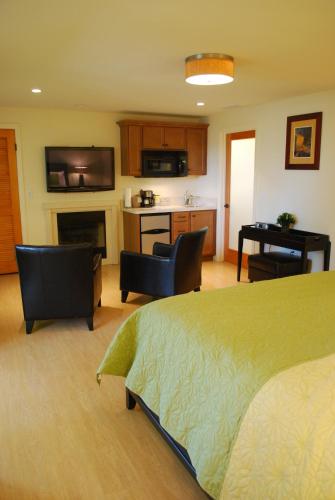 a bedroom with a bed and a kitchen with a fireplace at Bella Capri Inn and Suites in Camarillo