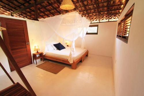 a bedroom with a bed with a mosquito net at ALTO BONITO in Atins