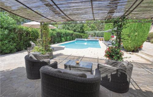 une terrasse avec des chaises en osier et une piscine dans l'établissement 4 Bedroom Cozy Home In Montauroux, à Montauroux