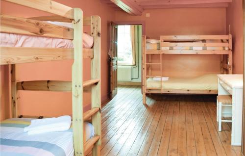 ヴァローニュにある3 Bedroom Beautiful Home In Valognesの二段ベッド3台とデスクが備わる客室です。