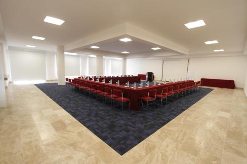 a conference room with a long table and red chairs at Hotel Montetaxco in Taxco de Alarcón