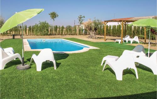 un gruppo di sedie bianche e una piscina di Stunning Home In Villanueva Del Duque a Villanueva del Duque
