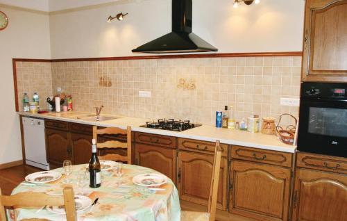 a kitchen with a table and a sink and a stove at Holiday Home Rue De L`escuraille in Suze-la-Rousse