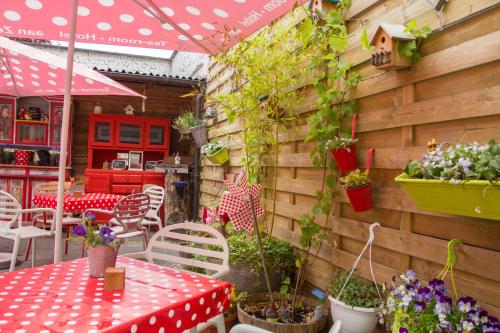 a patio with a table and chairs and plants at Hotel Aan Zee in De Panne