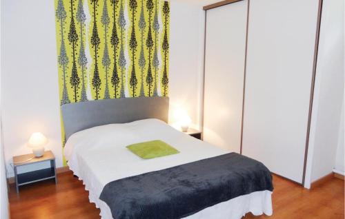 a bedroom with a white bed with a green blanket at Stunning Apartment In Pignan With Kitchen in Pignan