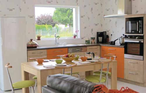 a kitchen with a wooden table and a counter top at Lovely Home In Brain-Sur-Alonnes in Brain-sur-Allonnes