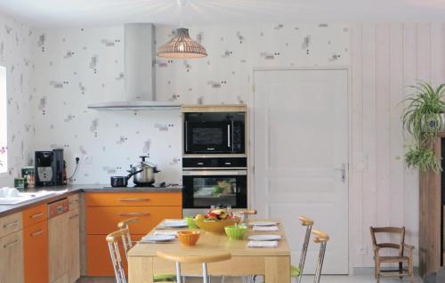 a kitchen with a table with a bowl of fruit on it at Lovely Home In Brain-Sur-Alonnes in Brain-sur-Allonnes
