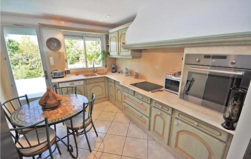 une grande cuisine avec une table et une salle à manger dans l'établissement 3 Bedroom Nice Home In Bagnols En Forêt, à Bagnols-en-Forêt