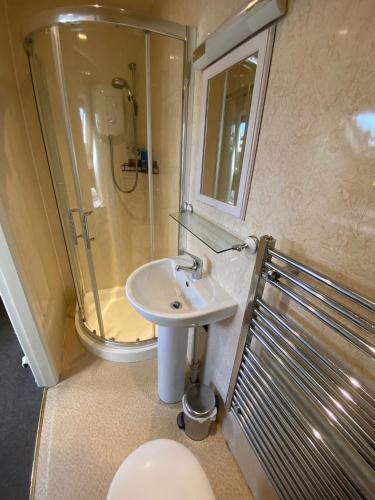a bathroom with a sink and a shower and a toilet at Autumn Leaves Guest House in Windermere