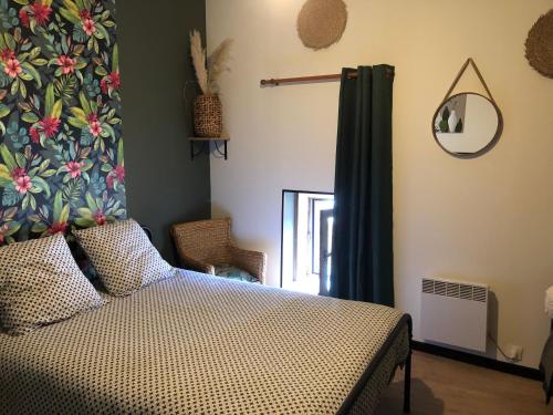 a bedroom with a bed and a mirror at Gite de la Huberderie in Quettehou