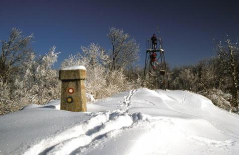 a snow covered field with a tower in the background at Sobe App Moj Hir bed and breakfast in Jastrebarsko