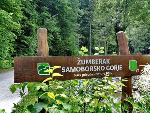 a wooden sign in the middle of a forest at Sobe App Moj Hir bed and breakfast in Jastrebarsko