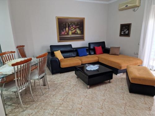 uma sala de estar com um sofá e uma mesa em Apartament Orion em Vlorë