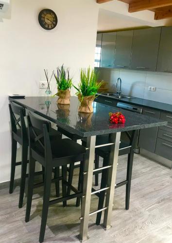a kitchen with a black table with plants on it at Adega da Prainha in Prainha de Baixo
