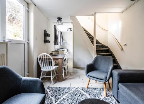 a living room with a staircase and chairs and a table at Duinhotel Haga in Zoutelande