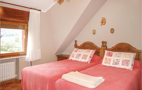 La Piñera的住宿－Gorgeous Home In Piloa With Kitchen，一间卧室设有两张带红色床单的床和窗户。
