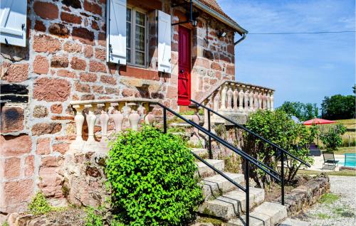 a brick house with a staircase and a red door at Gorgeous Home In Badefols D'ans in Teillots