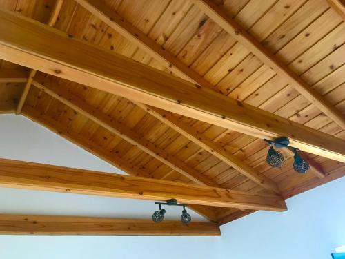 a wooden patio roof with lights under it at Adega da Prainha in Prainha de Baixo