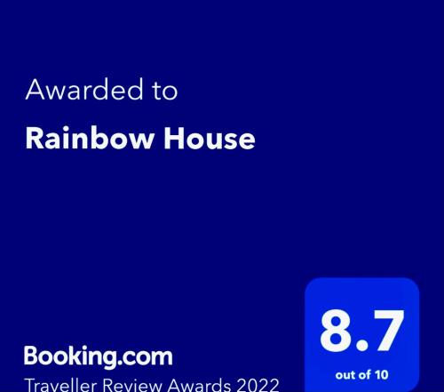 un cartel que dice que fue otorgado a la casa del arco iris en un fondo azul en Rainbow House, en Osaka