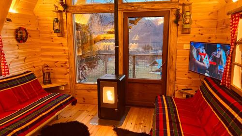 a living room with a fireplace in a log cabin at Tara Place - Camp Rabrenovic in Mojkovac