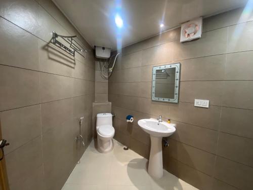 La salle de bains est pourvue de toilettes et d'un lavabo. dans l'établissement Hotel Amaira, à Darjeeling