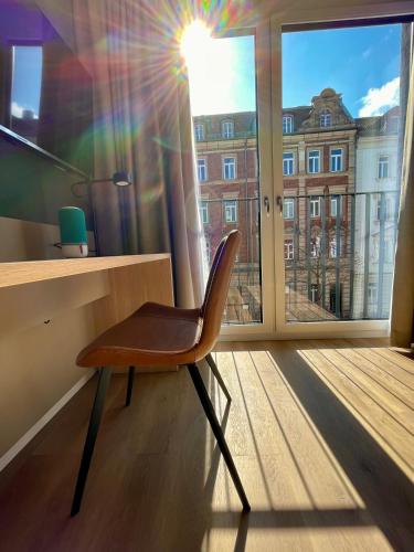 a chair sitting in a room with a window at zeitwohnhaus SUITE-HOTEL & SERVICED APARTMENTS in Erlangen