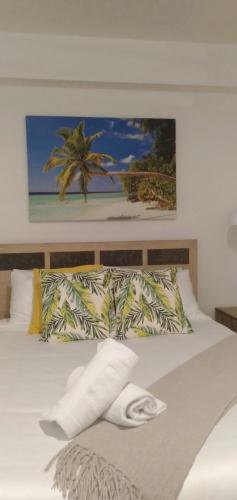 a bed with two pillows and a picture of a beach at Robe Marina Accommodation in Robe