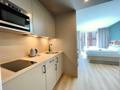 a kitchen with a sink and a counter top at zeitwohnhaus SUITE-HOTEL & SERVICED APARTMENTS in Erlangen