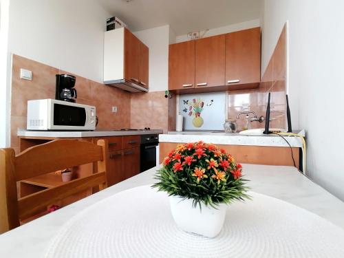 a kitchen with a table with a vase of flowers on it at Apartments Grebović in Dubrovnik