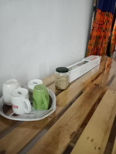 a table with coffee cups and a box on it at Karibu Nyumbani, Welcome Home in Mwanza