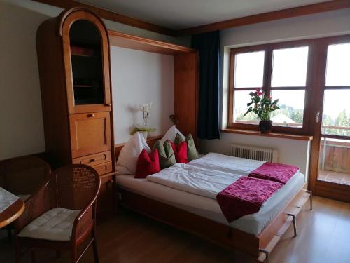 a bedroom with a bed with red and green pillows at Apartments Susanne und Jasmin - Haus Sonnleitn in Sonnenalpe Nassfeld
