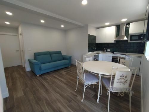 un soggiorno con tavolo e divano blu di Apartamento Manuela, totalmente nuevo, 8 km de la playa a Llanes