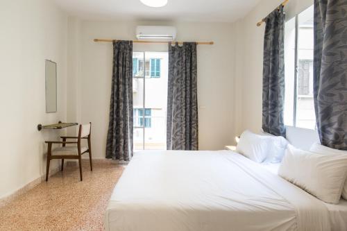 a bedroom with a white bed and a window at The Grand Meshmosh Hotel in Beirut