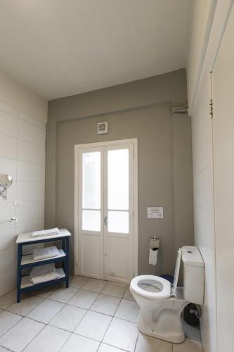 a bathroom with a white toilet and a window at The Grand Meshmosh Hotel in Beirut