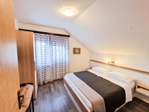 Un dormitorio con una cama grande y una ventana en Rooms Ruza, en Smoljanac